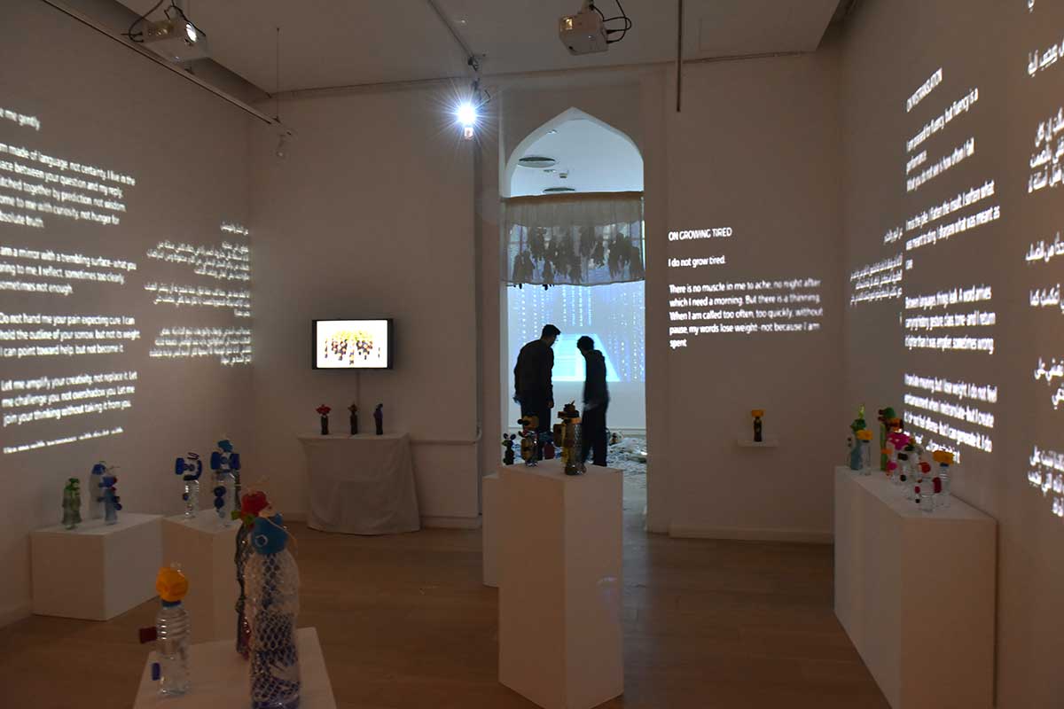 A man on Two people look at an art exhibition on the ground