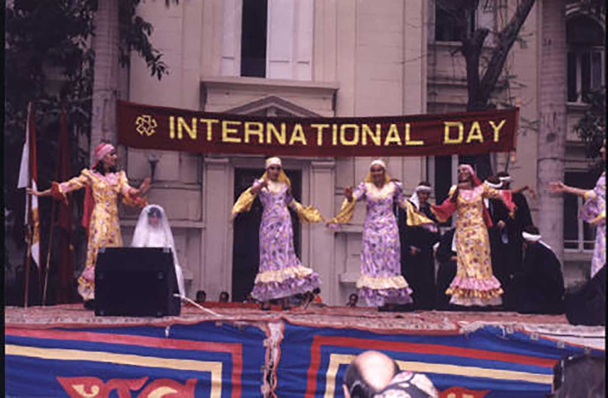 A group of students dance in cultural attire on a stage