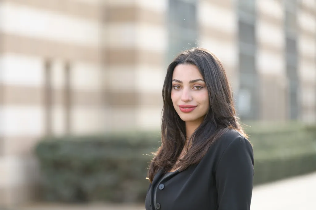 woman wearing black stands in front of a building