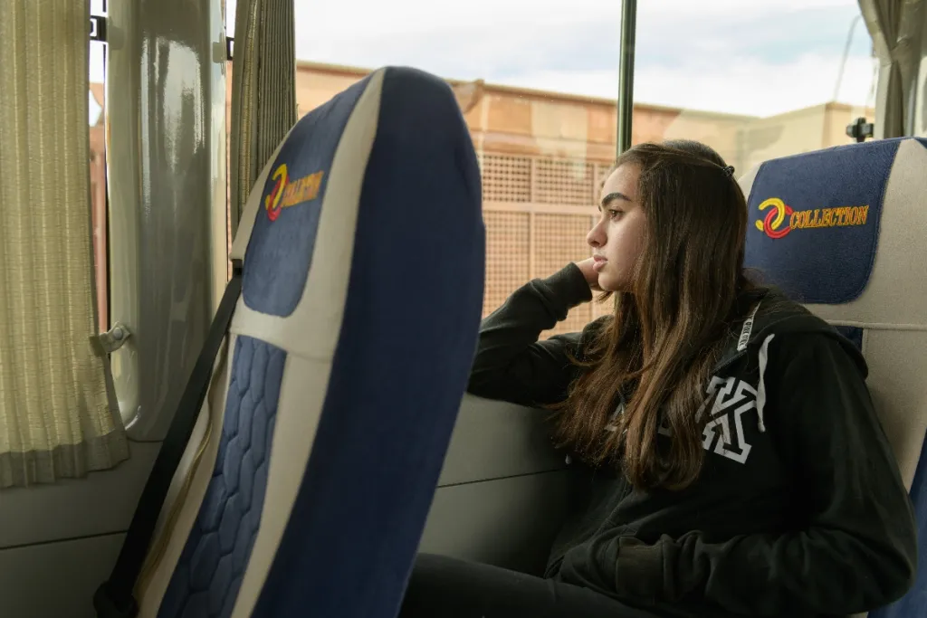 woman sits on a bus looking out the window