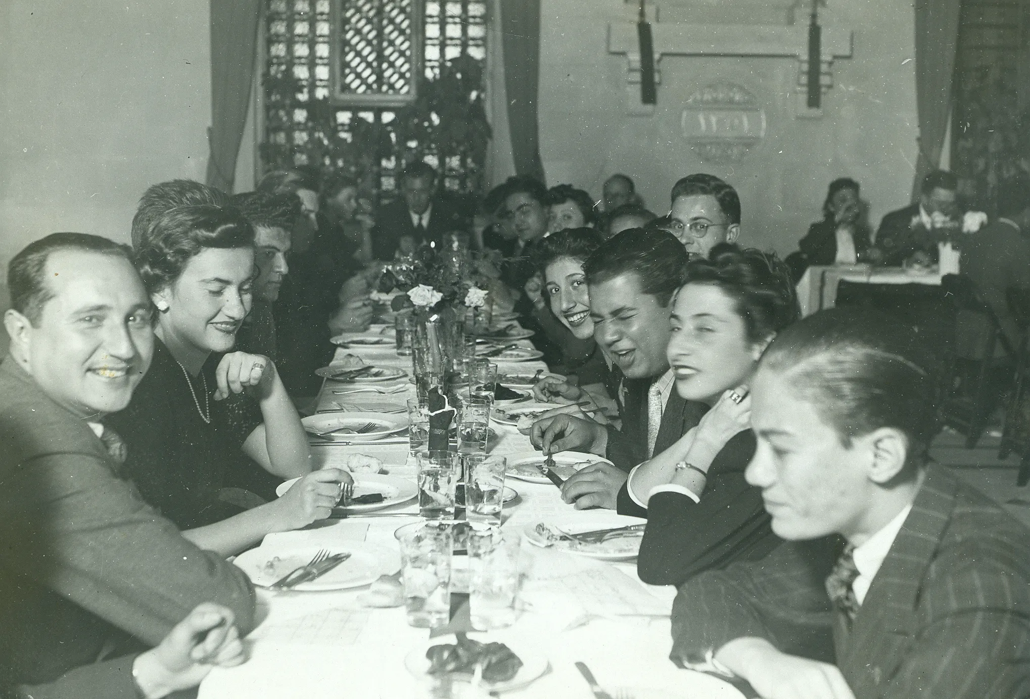 black and white photo of a large group of people at a long table