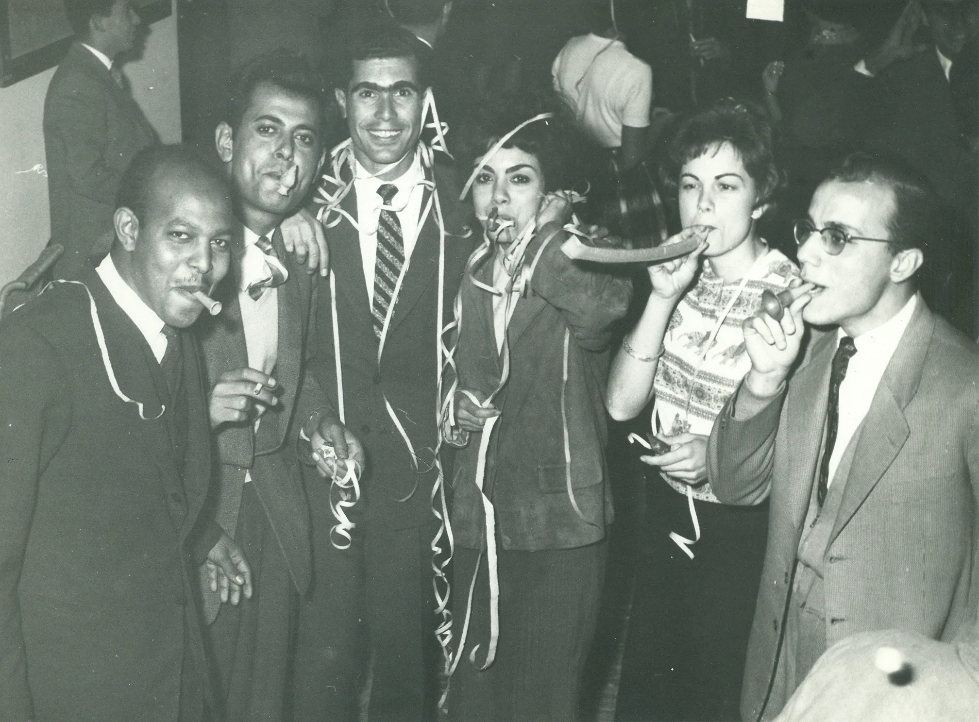 black and white photo of students posing for a photo with streamers 