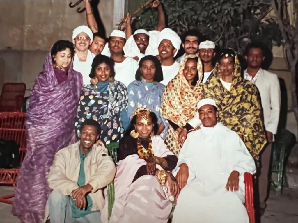 a group of people pose for a photo wearing traditional Sudanese attire
