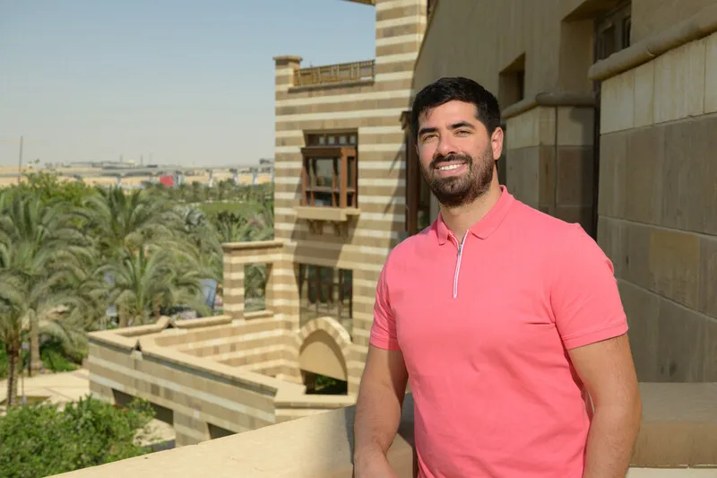 man standing on a balcony overlooking the AUC gardens and the outlying city