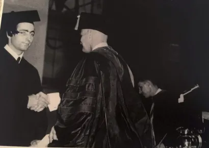 El Farouki receiving his diploma, shaking hands, in black and white