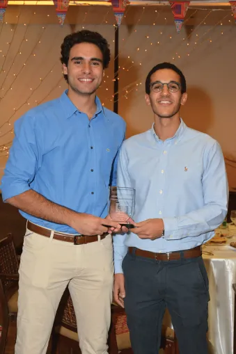 Tw students holding an award smile for the camera.