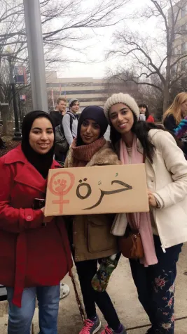 Three Egyptian women standing with an Arabic protest sign in Washington D.C.