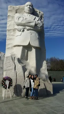 Three Egyptian women in front of a large stone carving of Martin Luther King